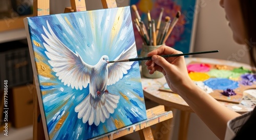 Woman painting white dove on canvas.