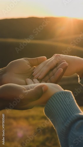Hands touching in sunset field