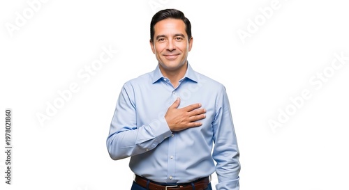 Man with hand on chest smiling sincerely on white background feeling grateful and expressing gratitude while standing in a studio wearing a blue shirt