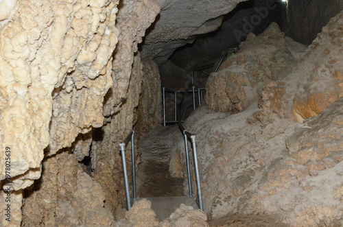 Foto Interior walkway inside Incirli Cave surrounded by textured limestone walls and stalactites with safety handrails