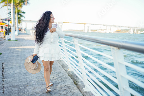 Fotografía Latina woman enjoying summer travel on waterfront promenade