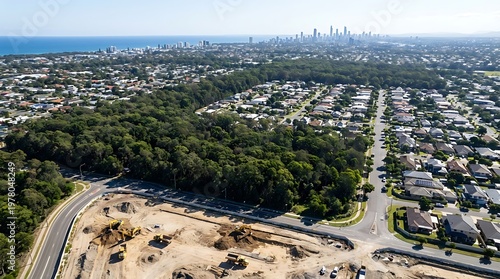 Bird's-eye view of land clearing and road construction for a new neighborhood development with the distant Melbourne CBD skyline under a clear sky