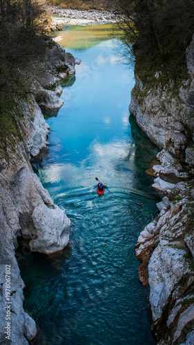 Kayaker paddling in Soca River turquoise canyon in Julian Alps Slovenia. Vertical shot