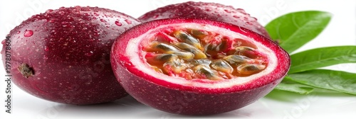Ripe passion fruit, halved and exposing its interior, surrounded by green leaves, against a white background