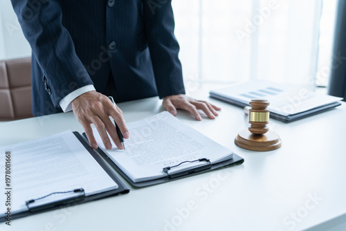 Lawyer in suit holding gavel and reading contract document