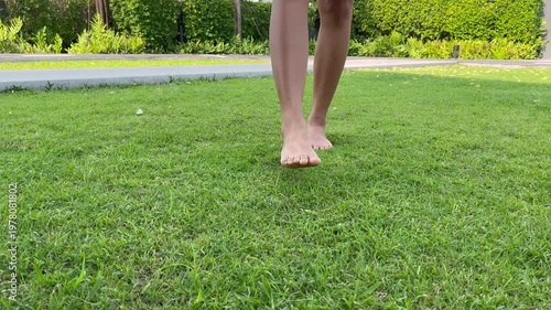 barefoot walking on fresh green grass in morning sunlight, representing healthy lifestyle, natural therapy, relaxation, mindfulness, grounding, and peaceful outdoor wellness routine