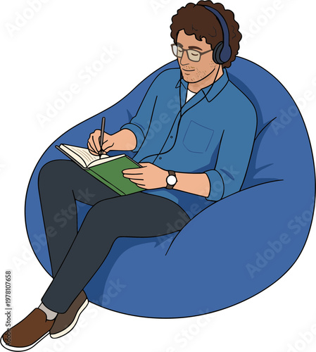 A man sits on a beanbag chair writing in a notebook while wearing headphones.