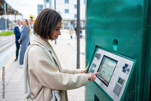 Obraz na plátně Woman buying public transport ticket at terminal kiosk