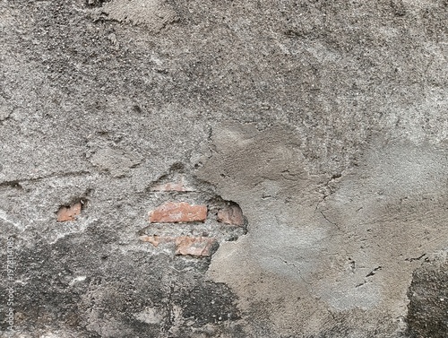 Φωτογραφία Close-up of a damaged, old concrete wall with peeling plaster and exposed brickwork