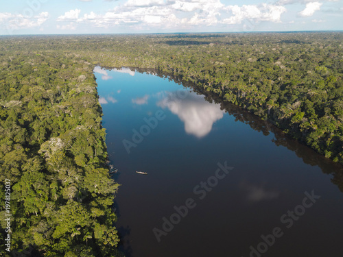 фотографія Aerial view of a lone canoe on a mirror-like jungle lake in the Tambopata National Reserve, Amazon Rainforest, Peru