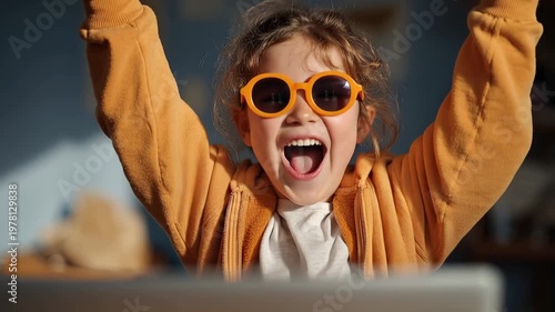 Joyful child girl celebrates during online class at home with vibrant sunglasses in bright indoor space