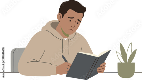 A man sits at a table reading a book next to a potted plant indoors.