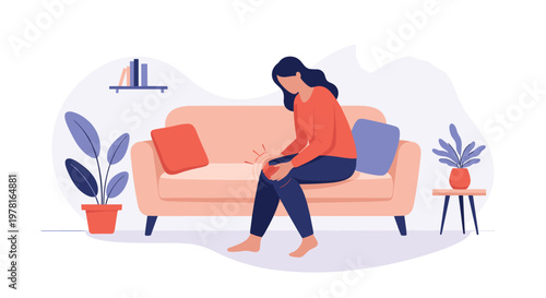 Concerned woman sitting on sofa at home holding her injured knee and suffering from joint pain or inflammation.