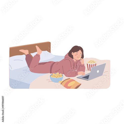 Woman lies on bed watching laptop with snacks