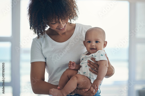 Foto Smile, mother and holding baby in home with love, parental support and bonding together