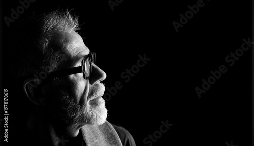 Foto side view portrait, head shot of a mature man in low key looking up, black and w