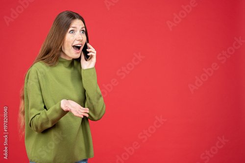 Billede på lærred Astonished woman talking on phone looking away at empty space