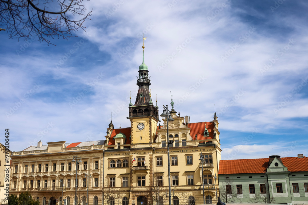 Obraz premium Historic town hall with clock tower under a bright blue sky with wispy clouds