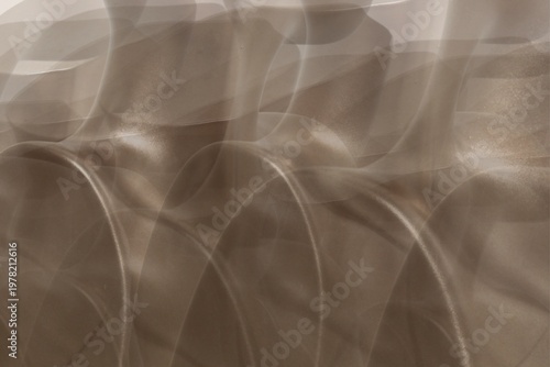 Soft, flowing curves ripple across the frame. Warm, muted tones evoke calm and quiet beauty. Abstract patterns suggest movement, grace, and depth. Ideal for tranquil backgrounds or minimalist design