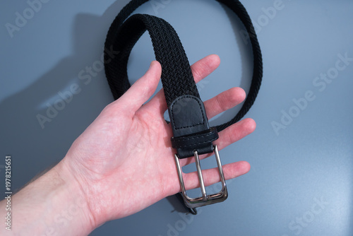 Hand Holding Black Leather Belt by Buckle