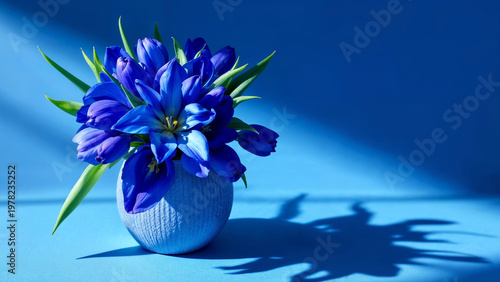 Blue flowers arranged in vase casting shadow on surface