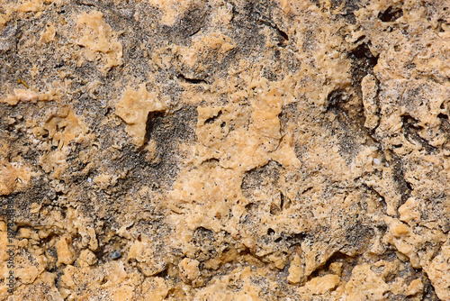 Obraz na płótnie Close-up of natural stone surface with rough texture in beige and gray tones