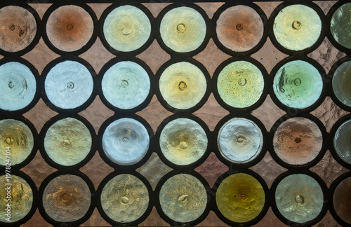Pattern of traditional bullseye glass (Crown glass)  window in old Hungarian church close up