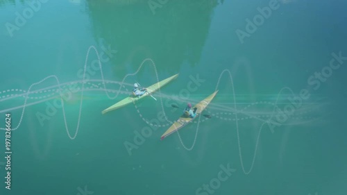 Two paddlers in kayaks starting strokes on green lake, tech waves flowing around boats for training