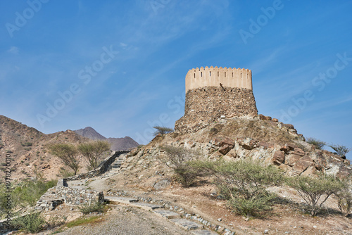 Historic stone watchtower and defensive wall in Fujairah mountains, UAE