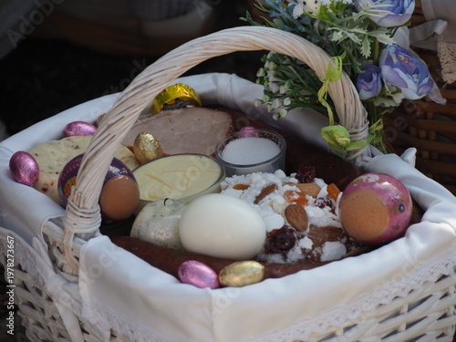 White wicker Easter basket with eggs and flowers during traditional spring holiday celebration