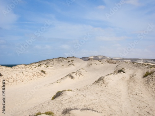 Desert landscape in Cape Verde with visible roads. The sky is partly cloudy.