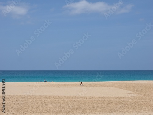 The vast beach of Santa Monica (Boa Vista Island, Cape Verde). Several anonymous figures are very far away. Day, almost clear.