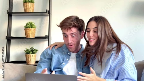 Joyful Young Couple Reacts with Excitement to Good News on Laptop, Celebrating Success Together
