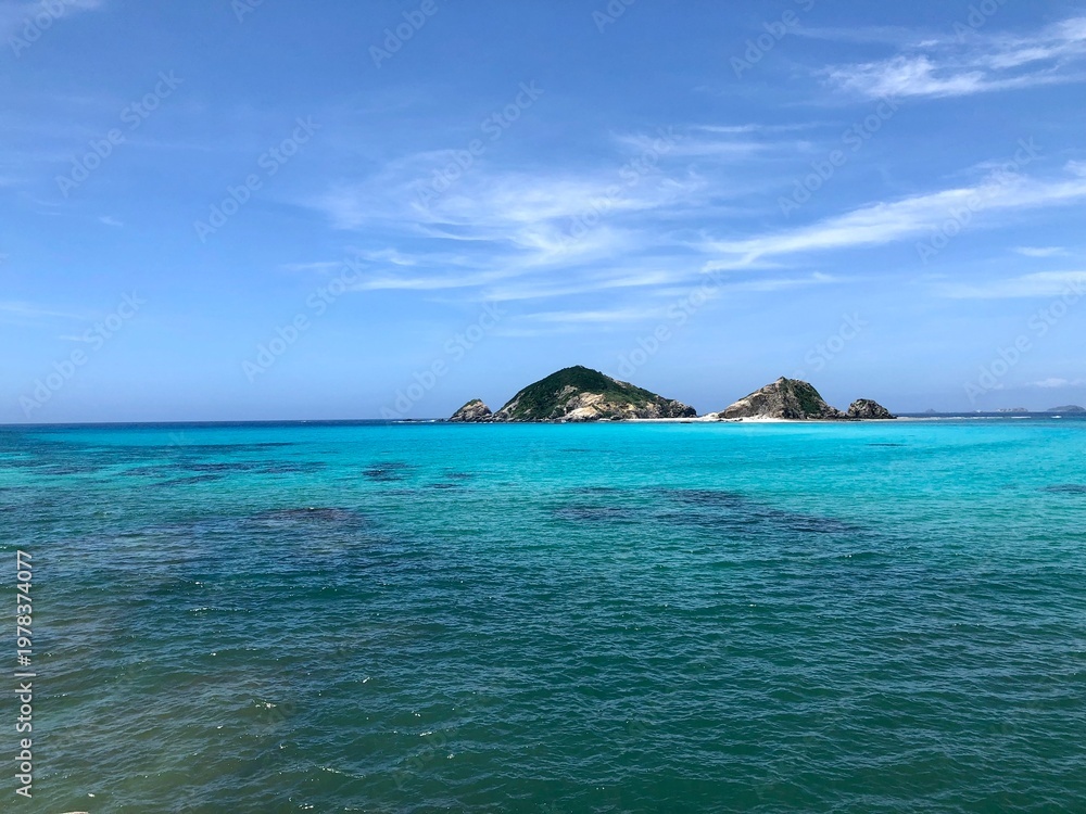 Naklejka premium Small Tropical Island Floating in Transparent Emerald Green Sea