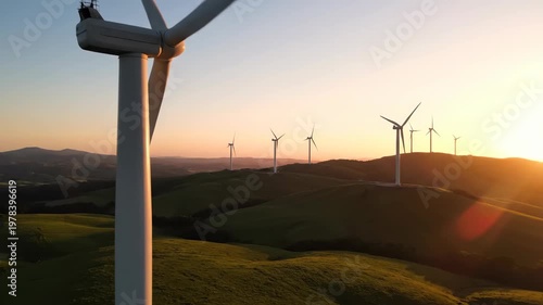 Wind turbines on grassy hills at sunset