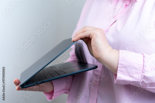 Quadro su tela Woman opening laptop in minimalist workspace