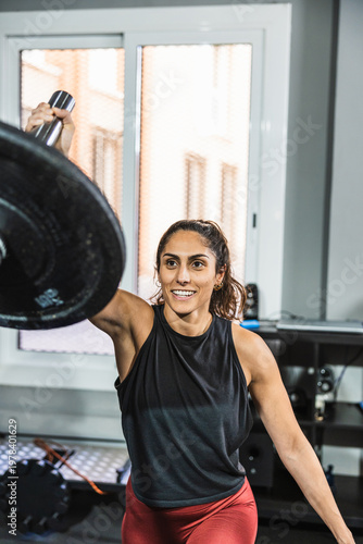 Tablou pe pânză Woman performing functional training with weight plate