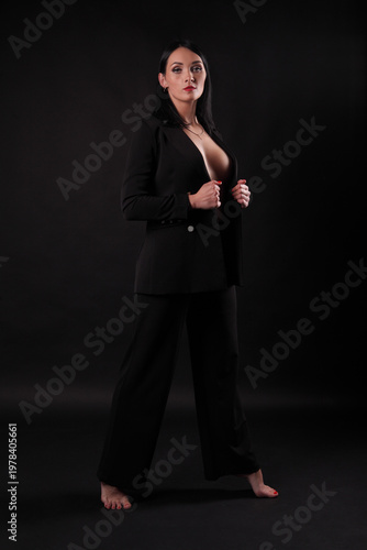 Sexy fashion woman in black suit on dark background