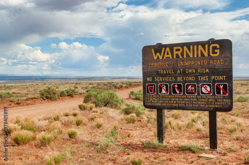 Fotografía Warning sign declaring absence of services on the unpaved dirt road through the