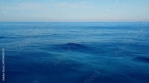 Deep blue ocean water with small waves on the surface under a clear sky during daytime