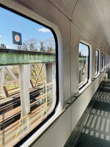 Interior of a train, bright atmosphere, view of the railway tracks from a window