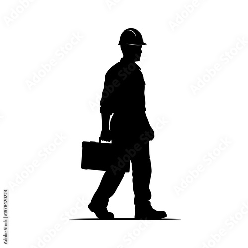 Silhouette of a construction worker in a hard hat carrying a toolbox while walking.