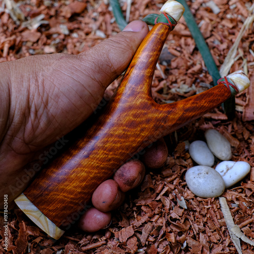 slingshot is made from tiger striped rosewood on a sawdust background