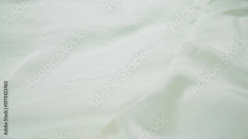 White fabric cloth falling in slow motion with soft flowing texture minimal background