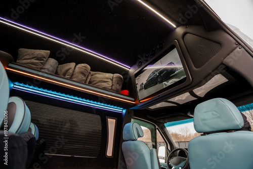 Interior View of Luxury Camper Van with Integrated LED Lighting and Entertainment Screen in Modern Style