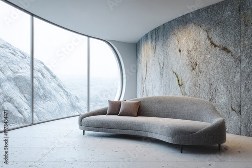 Modern curved sofa sits before a large window with mountain view.