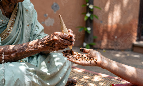 Wallpaper Mural Elderly woman applying mehndi on younger girl's hand during festival celebration, concept of Honoring Asian and Pasifika Ancestry Month   Torontodigital.ca