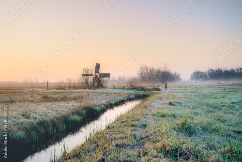 Golden dawn light kisses frosted fields and quiet canals.
