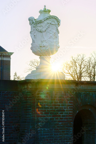 Sunburst pierces through bare branches, casting a golden glow.