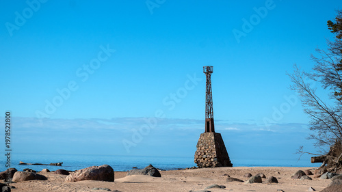 Fényképezés landscape with a lighthouse on the seashore, which is formed by stone masonry in